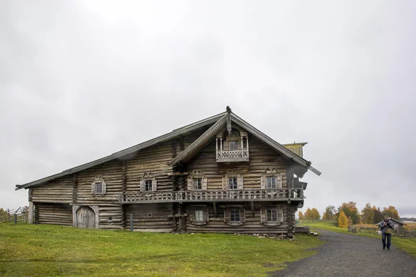 Karelen, Ryssland - 27 augusti 2019: Solnedgång landskap med utsikt över Transfiguration Church och bondgård hus på ön Kizhi, Karelen regionen, Ryssland i regnet — Stockfoto