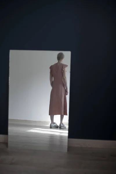 Reflejo de la joven desde atrás, entrando en la distancia, en el espejo —  Fotos de Stock