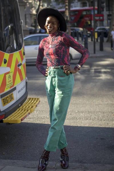 Λονδίνο, Uk- 13 Σεπτεμβρίου 2019: Άνθρωποι στο δρόμο κατά τη διάρκεια της Εβδομάδας Μόδας του Λονδίνου. Κορίτσι με μαύρα στενά τζιν, ένα μπορντό ζιβάγκο και ένα φαρδύ καπέλο — Φωτογραφία Αρχείου