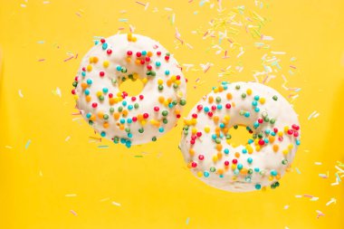 Sarı arka planda kremalı ve şekerli leziz donut. Boşluğu kopyala