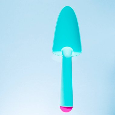 Bahçe seti: Mavi arka plan üzerinde çalışmak için plastik mavi kürek. Boşluğu kopyala.