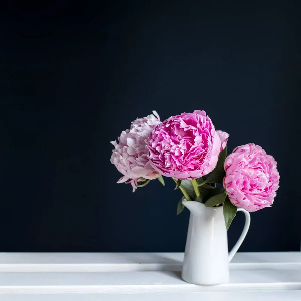 Trois Pivoines Rouges Dans Une Cruche Blanche Sur Fond Noir — Photo