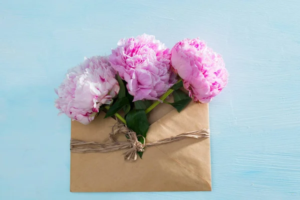 Pinkfarbene Pfingstrosen Großaufnahme Frühlingsblumen Zum Muttertag Braunen Umschlag Auf Hellblauem — Stockfoto