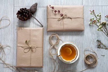 Hediye paketi için çeşitli eşyalar masanın üzerinde. Hediyeler paketlendi bile. Koni, paketlenmiş kitaplar.