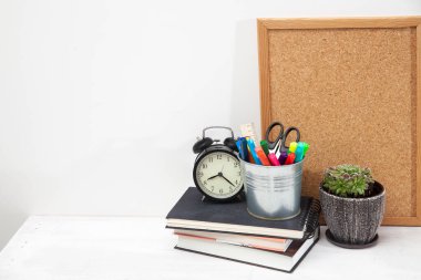 Uzayı kopyala İşyeri ofis çalışanı. Çalar saat, seramik kap, yazı tahtası, makaslı kova, keçeli kalem, cetvel, öğrenci masasında üç defter..