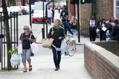 Londra, İngiltere - 17 Temmuz 2019, Colambia çiçek pazarından alınan hasır torbalarda iki yaşlı kadın çiçek taşıyor
