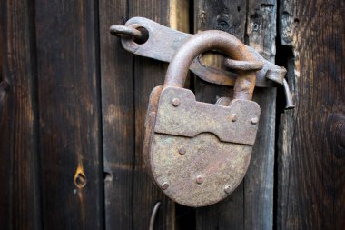 Ahşap ahır kapısında büyük paslı kilit.