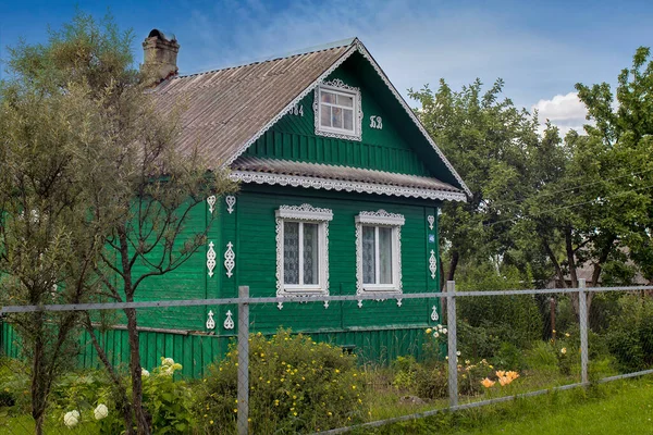 Yazın Rus kırsal arazisi, yeşillikte nehir kıyısındaki köy evleri.