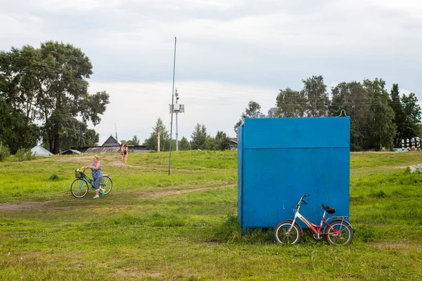 Belozersk ロシア 8月2020 Belozerskの街の堤防 ヴォロダ地方 男の子は湖の近くの運河で泳ぐ 自転車を持っている女性がビーチに行きます — ストック写真