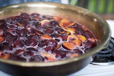 Limonlu erik reçeli ve gaz ocağında bakır bir leğende baharat pişirmek.