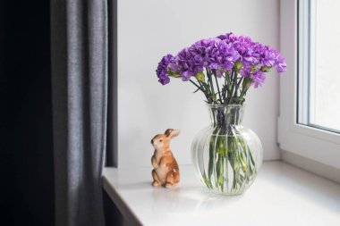 Masa dekorasyonu gibi farklı boyutlarda yuvarlak bir vazoda leylak karanfiller.