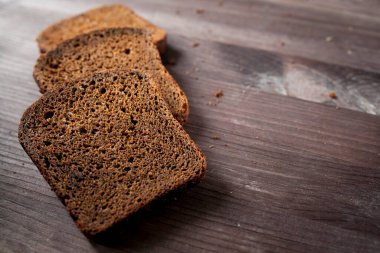 Kesme tahtasında dilimlenmiş çavdar ekmeği. Köy arka planında tohumlu tam tahıllı çavdar ekmeği. Uzayı kopyala Metin için yer