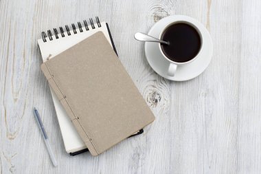 Boş not defteri, kahve fincanı ve tahta kalemi olan masa. Düz görünüm kopyalama alanı yatıyordu. Üst görünüm