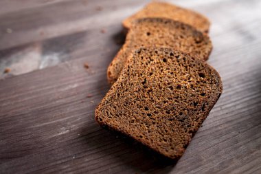Kesme tahtasında dilimlenmiş çavdar ekmeği. Köy arka planında tohumlu tam tahıllı çavdar ekmeği. Uzayı kopyala Metin için yer
