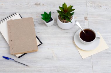 Boş not defteri, kahve fincanı ve tahta kalemi olan masa. Düz görünüm kopyalama alanı.