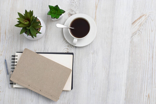 Office desk wood table of Business work place, notebook, artificial plant and coffee cup with copy space.