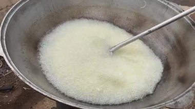 İnce doğranmış soğanlar tencerede yağda kızartılır ve pilav hazırlamak için karıştırılır..