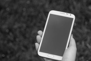 Akıllı telefon kullanan kadın elleri, yeşil doğa geçmişi