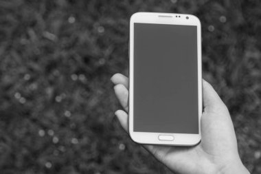 Akıllı telefon kullanan kadın elleri, yeşil doğa geçmişi