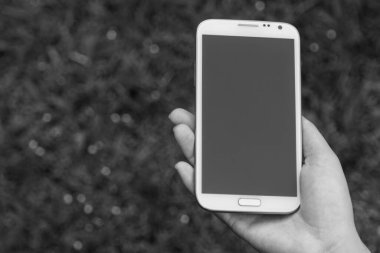 Akıllı telefon kullanan kadın elleri, yeşil doğa geçmişi