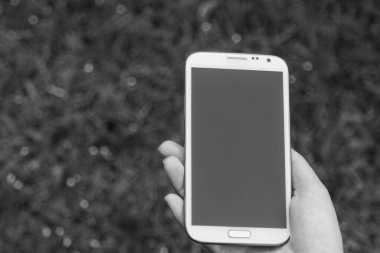 Akıllı telefon kullanan kadın elleri, yeşil doğa geçmişi