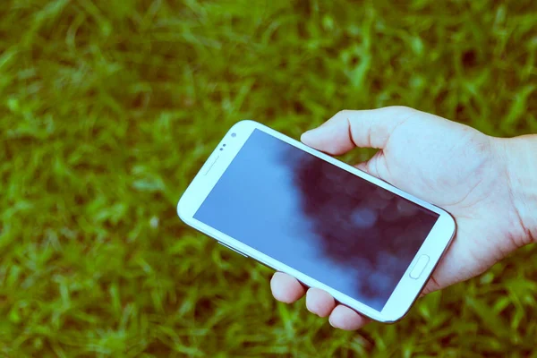 Close up man using mobile smart phone green background