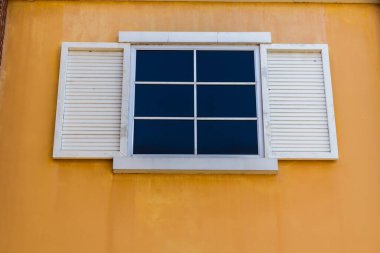 Beyaz pencereler ve sarı duvar arkaplanı