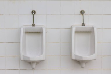 Erkekler tuvaletinde beyaz pisuarlar.