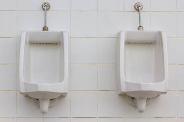 Erkekler tuvaletinde beyaz pisuarlar.