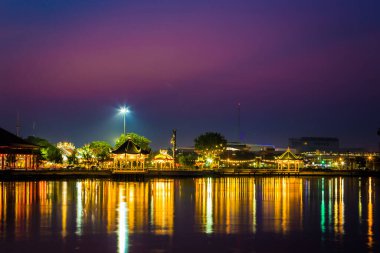 Şehrin günbatımında parktaki yansımaları su silueti.