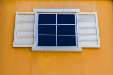 Beyaz pencereler ve sarı duvar arkaplanı