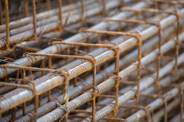 İnşaatta beton takviyesi için kullanılan çelik inşaat ızgarasına yakın çekim. Dayanıklılık için gerekli olan paslı çubuk deseni gösteriliyor.