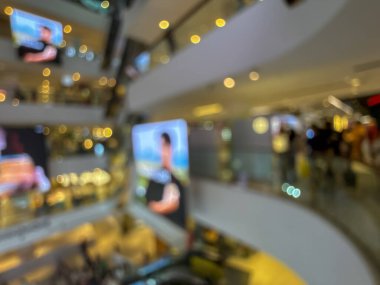 Hareketli bir alışveriş merkezinin bulanık görüntüsü modern bir perakende satış ortamının canlı atmosferini yakalıyor. İnsanlar alışveriş yaparken görülüyor.