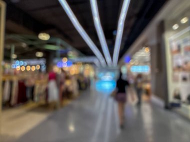 Hareketli bir alışveriş merkezinin bulanık görüntüsü modern bir perakende satış ortamının canlı atmosferini yakalıyor. İnsanlar yürürken, alışveriş yaparken ve eğlenirken görülürler.