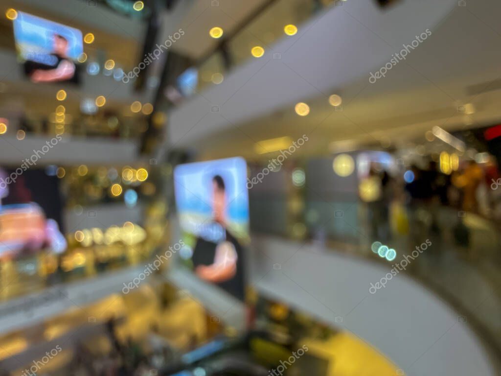 Blurred image of a bustling shopping mall, capturing the vibrant atmosphere of a modern retail environment. People are seen shopping