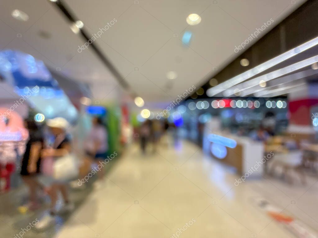 Blurred image of a bustling shopping mall, capturing the vibrant atmosphere of a modern retail environment. People are seen shopping