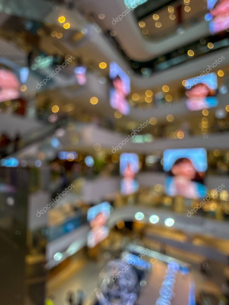Blurred image of a bustling shopping mall, capturing the vibrant atmosphere of a modern retail environment. People are seen shopping