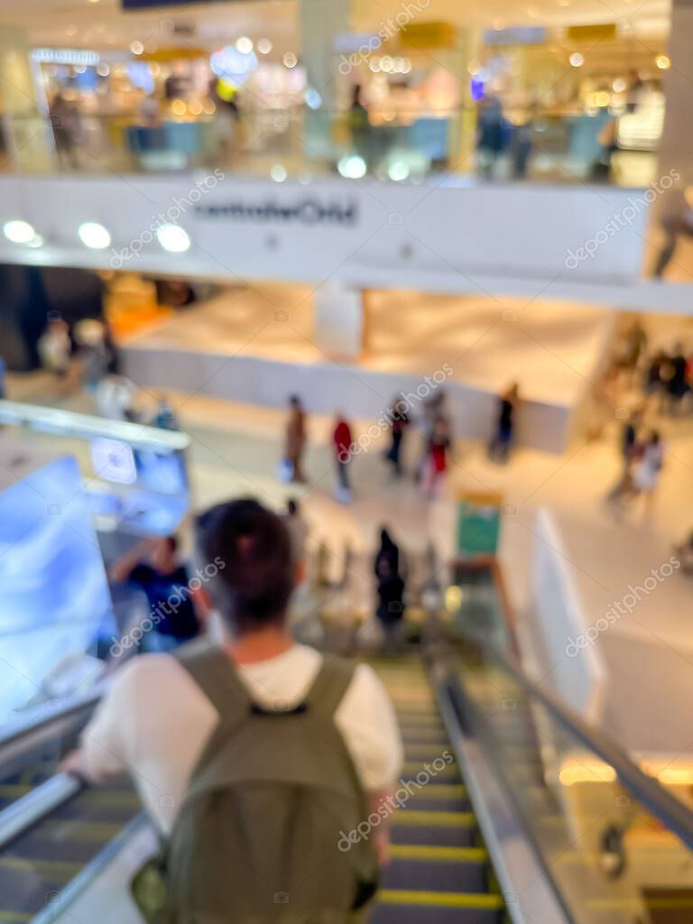 Blurred image of a bustling shopping mall, capturing the vibrant atmosphere of a modern retail environment. People are seen shopping