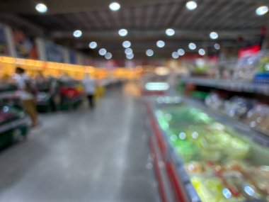 Raflarda çeşitli taze meyve ve sebzelerin sergilendiği bir market üretim bölümünün bulanık görüntüsü. Resim ürünün canlı renklerini ve dokularını yakalar