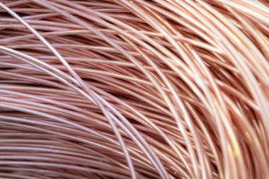 Parlak yüzeyi olan sarmalanmış bakır kabloların yakın çekimi, karmaşık örtüşen desenler, sıcak ışıklandırma..