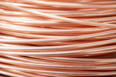 Parlak yüzeyi olan sarmalanmış bakır kabloların yakın çekimi, karmaşık örtüşen desenler, sıcak ışıklandırma..