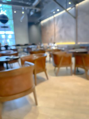 Ahşap sandalyeli, masalı, sıcak ışıklandırmalı ve büyük pencereli modern bir kafe.