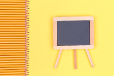 Kalemler ve sarı bir arka plan siyah tebeşir tahtaya. Geri okul kavramı. Yatay