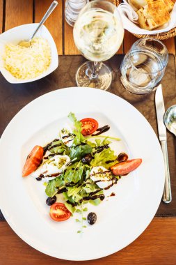 Caprese salatası masasında. İtalyan restoranın açık teras. Yaz otantik yemek kavramı. Dikey