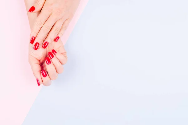 Mãos Mulher Com Manicura Vermelha Elegante Fundo Azul Pastel Rosa — Fotografia de Stock