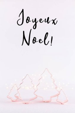 Noel ağacı bakır çerez kesici beyaz köpüklü arka planda bokeh ışıkları ile ailesi. Tatil Noel ve yeni yıl kartı arka plan. Dikey. Tatil ifadeler Fransızca