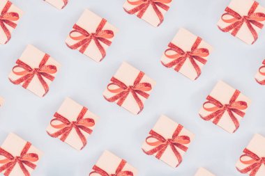 Zanaat kutularının kırmızı kurdele ile Seamless modeli yay. Sevgililer günü kavramı. Şık minimalist düz tasarım arka plan pop sanat tarzı yatıyordu. Yatay