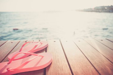 Gün batımı sırasında Flip flop, ahşap iskele. Lüks Tatil resort. Tatil kaçamağı kavramı. Yatay, seçmeli soğuk tonlama