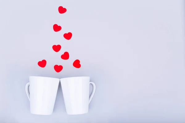 White china mug with  glitter heart confetti. Valentine day concept. Trendy minimalistic flat lay design background. Horizontal