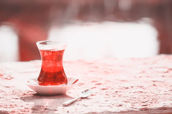 Hot turkish tea outdoors near water. Turkish tea and traditional turkish culture concept. Horizontal. Toned image. Living coral theme - color of the year 2019